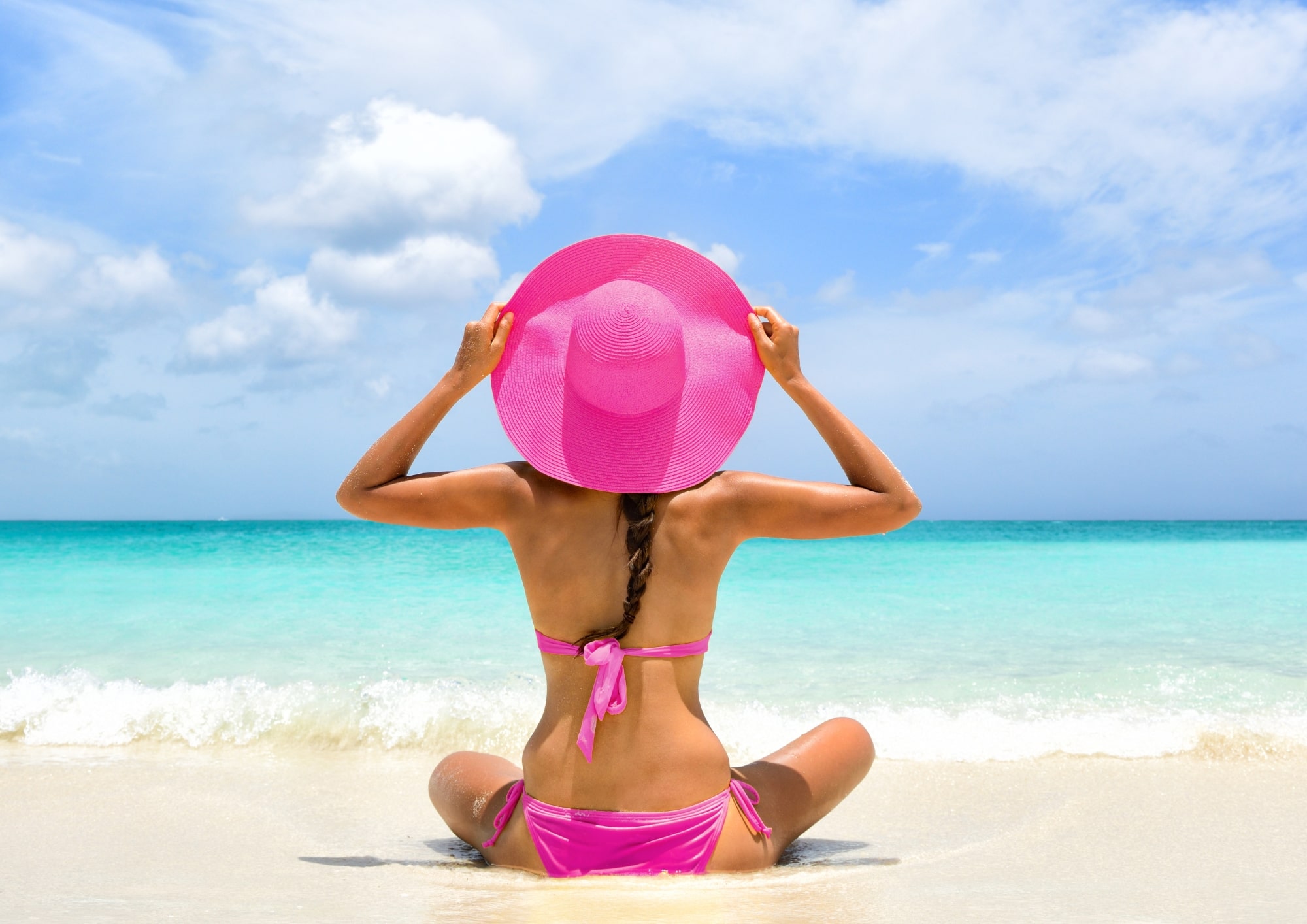 Žena sedí zády u moře během menstruace – klid, přijetí a pohodlí i během svých dnů.